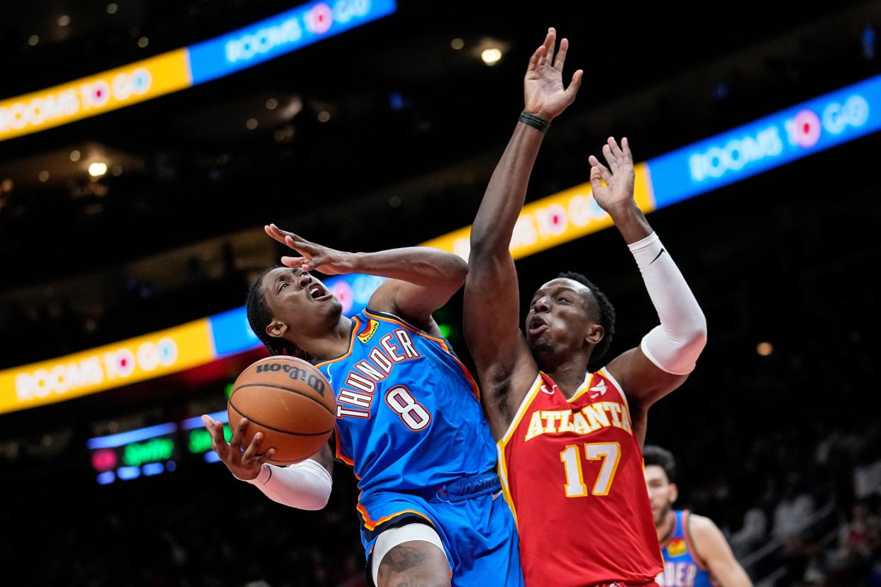 Oklahoma City Thunder forward Jalen Williams (8) is foulded by Atlanta Hawks forward Onyeka Okongwu (17) as he goes in for a shot during the second half of an NBA basketball game Wednesday, Jan. 3, 2024, in Atlanta. (AP Photo/John Bazemore)