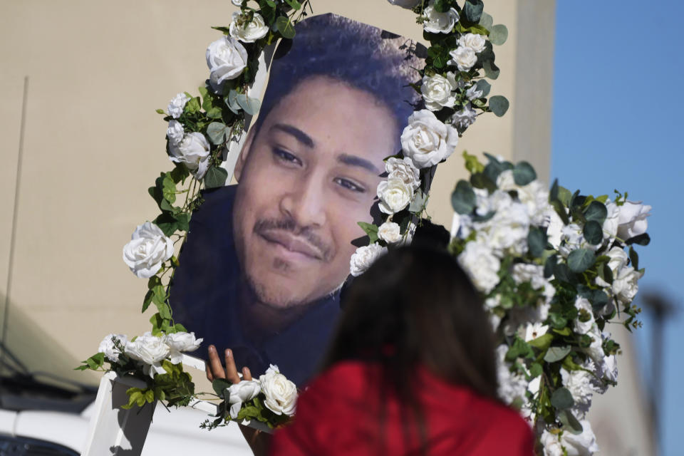 A photograph of one of the five victims of a weekend mass shooting at a nearby gay nightclug is carried to a makeshift memorial on Tuesday, Nov. 22, 2022, in Colorado Springs, Colo. Anderson Lee Aldrich opened fire at Club Q, in which five people were killed and others suffered gunshot wounds before patrons tackled and beat the suspect into submission. (AP Photo/David Zalubowski)