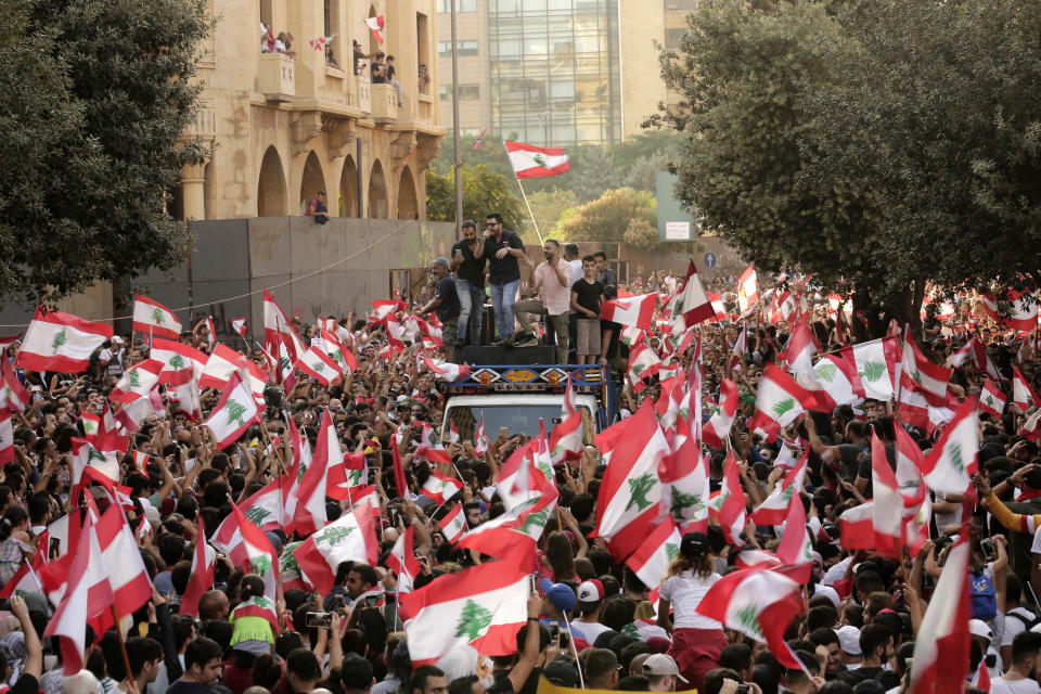 Anti-government protesters shout slogans in Beirut, Lebanon, Sunday, Oct. 20, 2019. Tens of thousands of Lebanese protesters of all ages gathered Sunday in major cities and towns nationwide, with each hour bringing hundreds more people to the streets for the largest anti-government protests yet in four days of demonstrations. (AP Photo/Hassan Ammar)