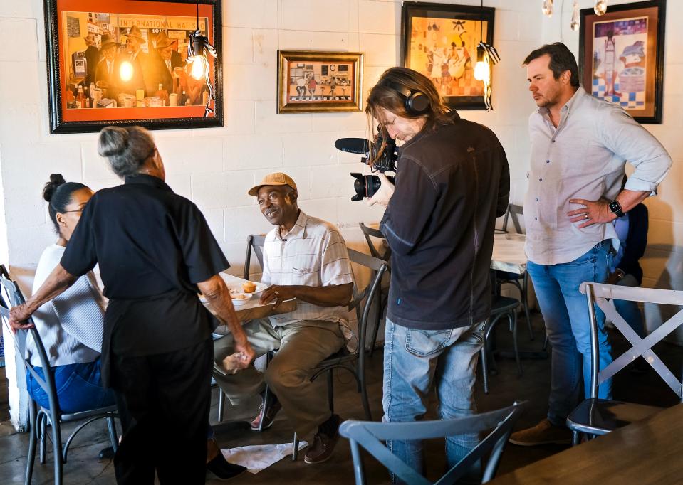 Florence's Restaurant owner Florence Jones Kemp, left, visits with Arthur Hurst, owner of the Jewel Theatre, as camera operator Kevin Ford films and director Matt Payne looks on during work on the upcoming documentary "The Jewel" in May at Florence's Restaurant.