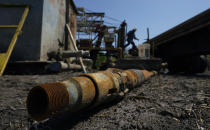 An oil well worker moves equipment at a site on the Rooke family ranch where an orphaned well was plugged, Tuesday, May 18, 2021, near Refugio, Texas. There are 3.2 million abandoned oil and gas wells in the U.S., according to the Environmental Protection Agency. About a third were plugged with cement, which is considered the proper way to prevent harmful chemical leaks. But most, about 2.1 million by the EPA's count, haven't been plugged at all. (AP Photo/Eric Gay)