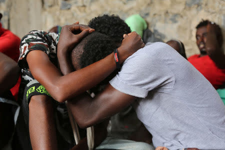 Somali refugees who survived an attack on a boat off Yemen's coast in the Red Sea hug each other as they sit at a detention center in the Houthi-held port of Hodeidah, Yemen, March 22, 2017. Picture taken March 22. REUTERS/Abduljabbar Zeyad