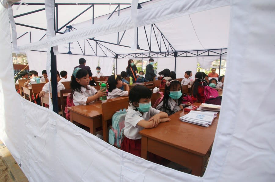 Children attend class in a temporary classroom set up by UNICEF, Monday Oct. 12, 2009, in Padang, Indonesia where a massive earthquake hit more than a week ago, leaving most of the city without electricity or running water for days. (AP Photo/Binsar Bakkara)