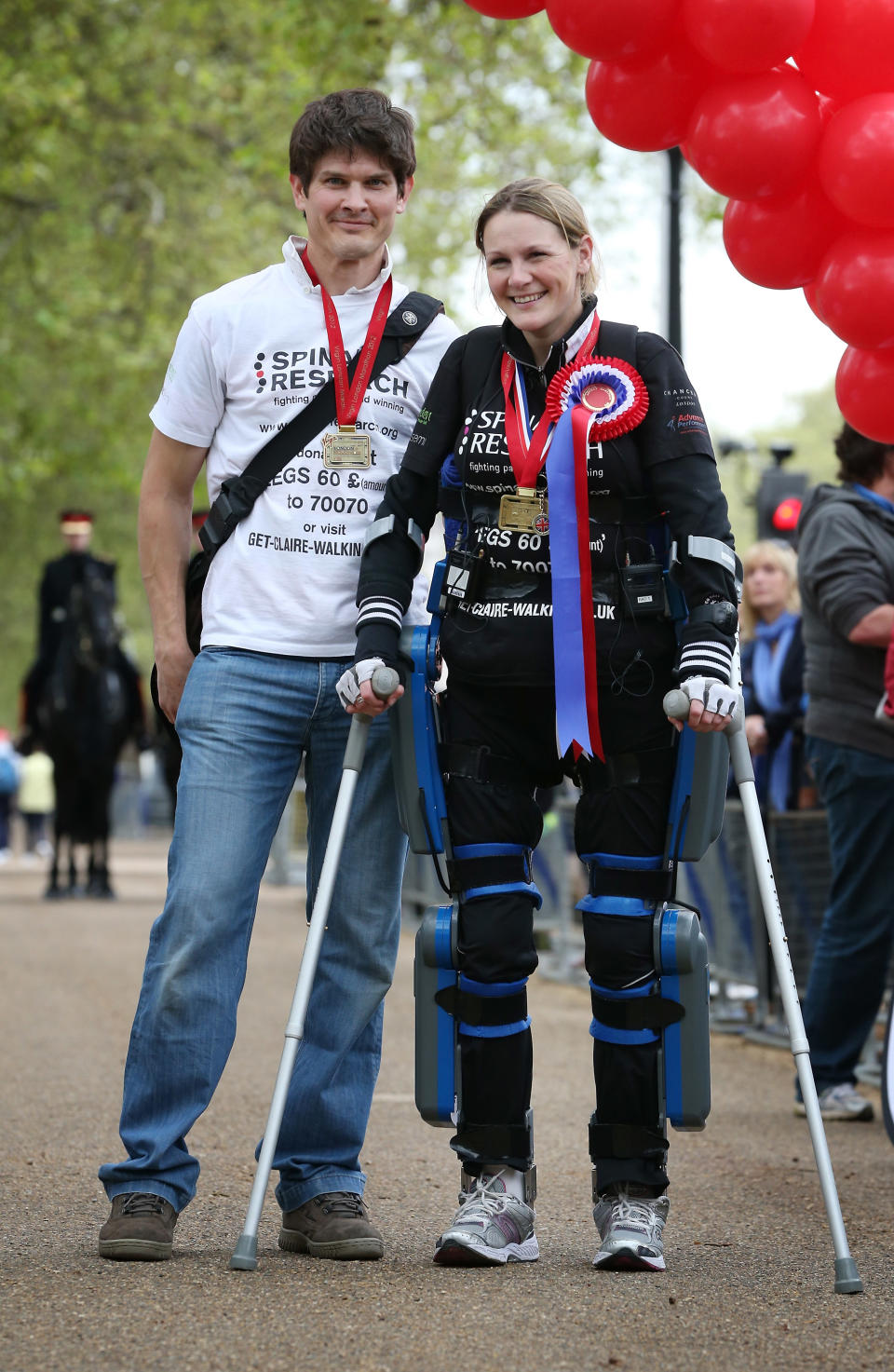 LONDON, ENGLAND - MAY 08: Claire Lomas stands with her husband Dan Spincer after crossing the finishing line of the Virgin London Marathon on May 8, 2012 in London, England. Ms Lomas, who is paralysed from the waist down after a riding accident in 2007, has taken 16 days to complete the 26.2 mile route. Starting out with 36,000 other runners she has averaged 2 miles a day with the help of a bionic ReWalk suit. (Photo by Peter Macdiarmid/Getty Images)