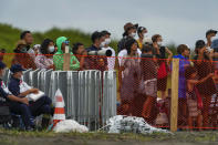 People watch from behind a security fence during the final day of the surfing competition at the 2020 Summer Olympics, Tuesday, July 27, 2021, at Tsurigasaki beach in Ichinomiya, Japan. The Olympic beach party that never was may be the only sore spot for surfing’s long-awaited debut that finished triumphantly this week. Some local Japanese fans and beachgoers did manage to find a way to lay eyes on the athletes and the competition site once the games began. (AP Photo/Francisco Seco)