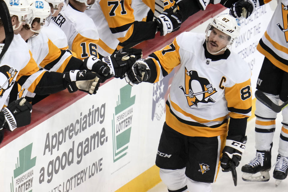 Pittsburgh Penguins' Sidney Crosby (87) returns to the bench after scoring against the Buffalo Sabres during the first period of an NHL hockey game in Pittsburgh, Saturday, Dec. 10, 2022. (AP Photo/Gene J. Puskar)