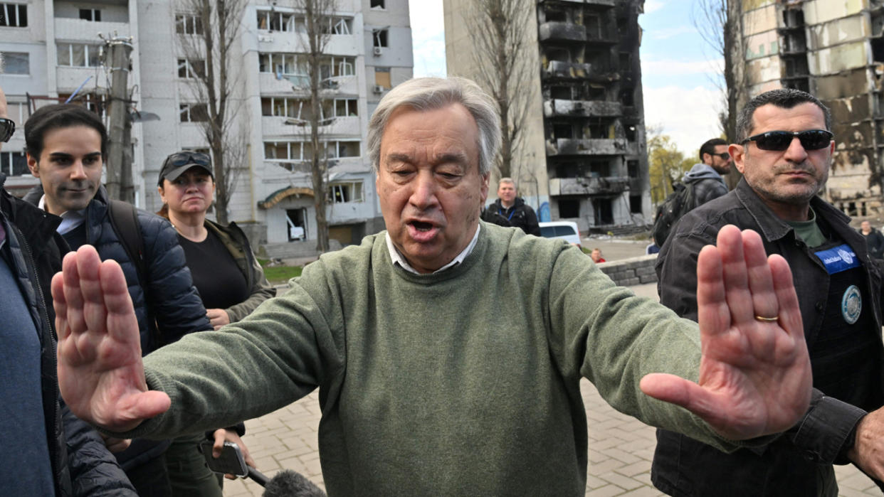 United Nations Secretary-General Antonio Guterres holds both hands out in front of him while speaking during a visit to a town in Ukraine.