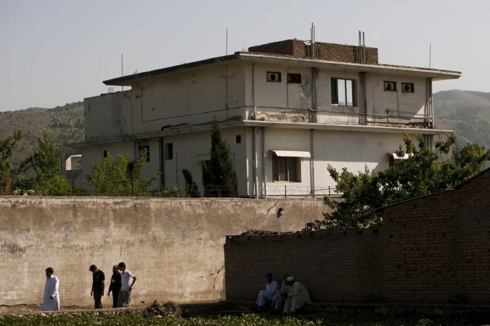 <div class="inline-image__caption"><p>People walk past Osama Bin Laden's compound, where he was killed during a raid by U.S. special forces, May 3, 2011, in Abottabad, Pakistan. </p></div> <div class="inline-image__credit">Getty </div>