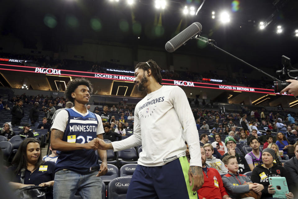 Minnesota Timberwolves' Derrick Rose, center, meets 18-year-old Make-a-Wish recipient Hunter Simmons, who is living with leukemia, prior to an NBA basketball game against the Los Angeles Lakers, Sunday, Jan. 6, 2019, in Minneapolis. (AP Photo/Stacy Bengs)