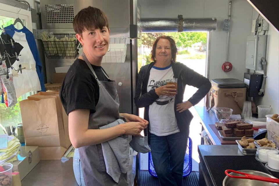 In this image provide by Ashley Hardin, Ashley Hardin, 38, of Seattle, and her mother, Lajay Gove, pose inside Layers Sandwich Co., a food truck Hardin runs with her husband, Avery Hardin, on May 29, 2021, in Seattle. Ashley Hardin will have about $108,000 in private student loan debt forgiven as part of a national settlement announced Thursday, Jan. 13, 2022, involving the student loan servicer Navient. The settlement, which still needs court approval, includes $1.7 billion in debt cancellation and $95 million in restitution, and it settles allegations of predatory lending practices by Navient. (Avery Hardin via AP)