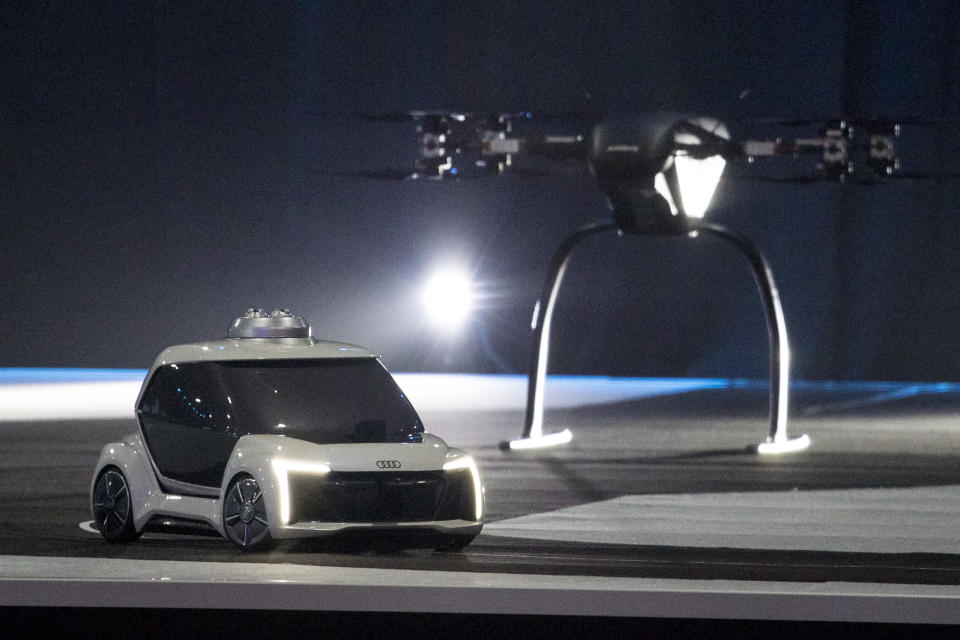 A working scale model of Pop.Up Next, a prototype designed by Audi, Airbus and Italdesign, drives away from the air module, rear, after landing during a presentation at the Amsterdam Drone Week in Amsterdam, Netherlands, Tuesday, Nov. 27, 2018. The two-seater vehicle combines ground transportation with vertical take-off and landing capabilities. (AP Photo/Peter Dejong)