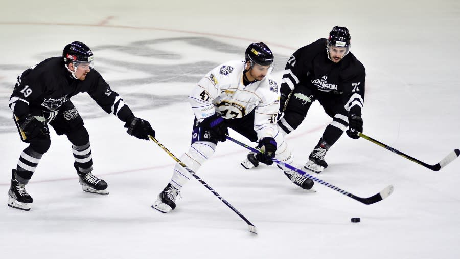 Nottingham Panthers Jordan Kelsall, centre, battles with Manchester Storm’s Tommy Parran, left, and Manchester Storm’s Callum Fryer during the Ice Hockey Adam Johnson memorial game between Nottingham Panthers and Manchester Storm at the Motorpoint Arena, Nottingham, England, Saturday, Nov. 18, 2023. The memorial game is held three weeks after Adam Johnson, 29, suffered a fatal cut to his neck during a game against Sheffield Steelers on Saturday, October 28. (AP Photo/Rui Vieira)