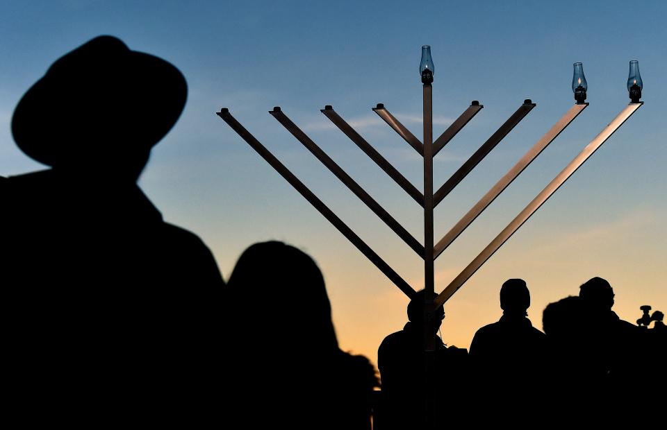 Residents celebrate the first day of Hanukkah at a menorah lighting ceremony at the downtown Public Square on Monday, November 29, 2021, in Nashville, Tenn. 