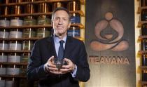 Howard Schultz, chief executive of Starbucks, holds a cup of tea as he poses for a portrait at his new Teavana store in New York, October 23, 2013. REUTERS/Carlo Allegri