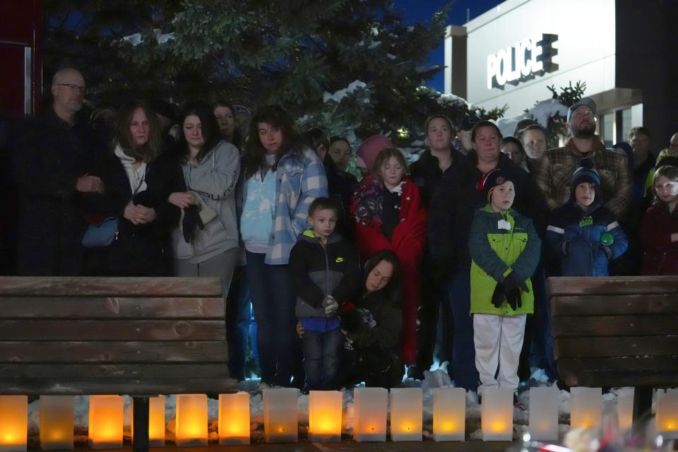 People attend a candlelight vigil after two police officers and a first responder were shot and killed Sunday in Burnsville, Minn.