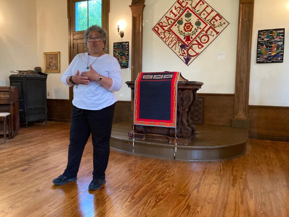 2022 resident Sonié Joi Thompson-Ruffin speaks with her fiber-art creations hung as a backdrop.