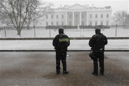 Members of the U.S. Secret Service Uniformed Division keep an eye on the White House during a snowstorm in Washington January 21, 2014. REUTERS/Larry Downing