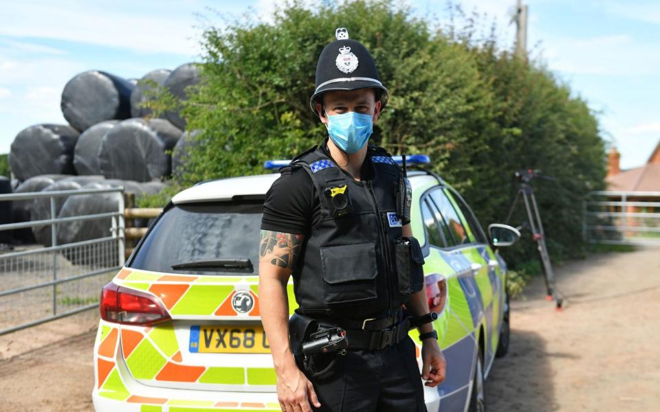 A police officer guards Rook Row Farm in Herefordshire, where a local lockdown has been imposed after a Covid outbreak among workers  - PA