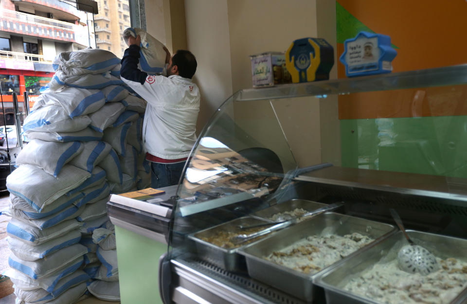 A Lebanese man sets up sand barriers at the window of a chicken shop, in a Shiite neighborhood of a southern suburb of Beirut, Lebanon, Tuesday, Jan. 28, 2014. After a wave of car bomb attacks on Hezbollah's stronghold south of Beirut that left scores of people dead or wounded over the past three months, shop owners scared of more bombs have set up sand barriers in front of their institutions to reduce damage in case more blasts occur. The attacks that hit the south Beirut area known as Dahiyeh (suburb) has sacred many people in the area and increased security measures by Lebanese troops and members of the militant group.(AP Photo/Hussein Malla)