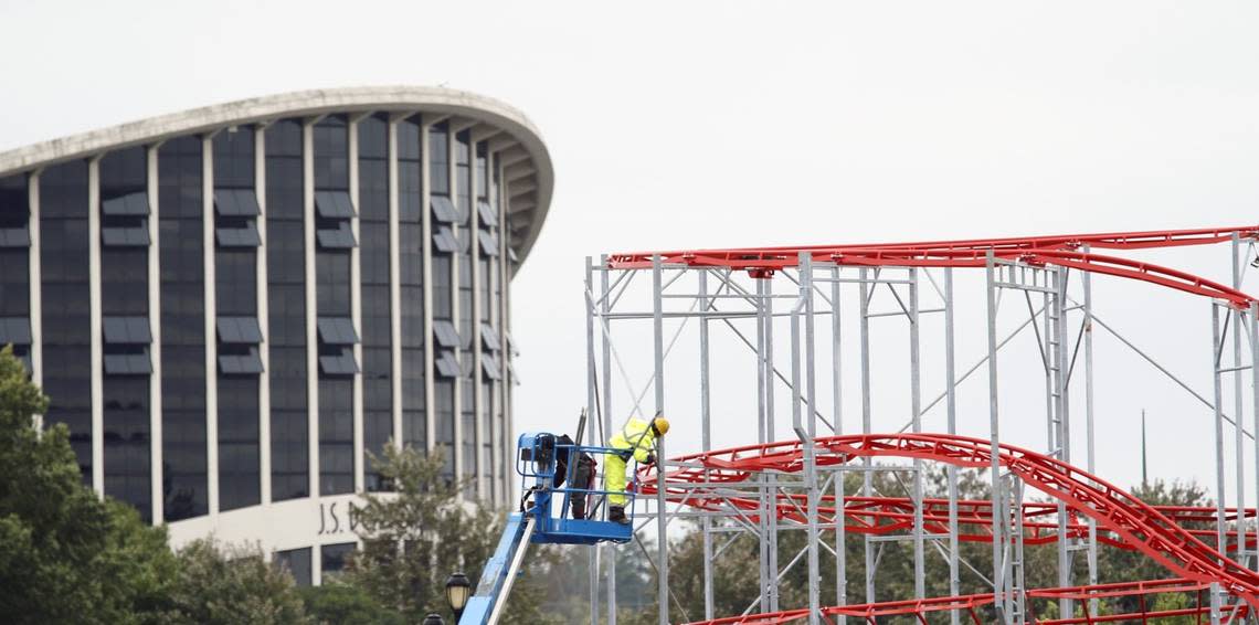 With the landmark Dorton Arena in the background, workers set up the Super Cyclone roller coaster ride for the upcoming N.C. State Fair at the Fairgrounds in west Raleigh on Oct. 5, 2015. This year the State Fair runs Oct 15 - 25, 2015.