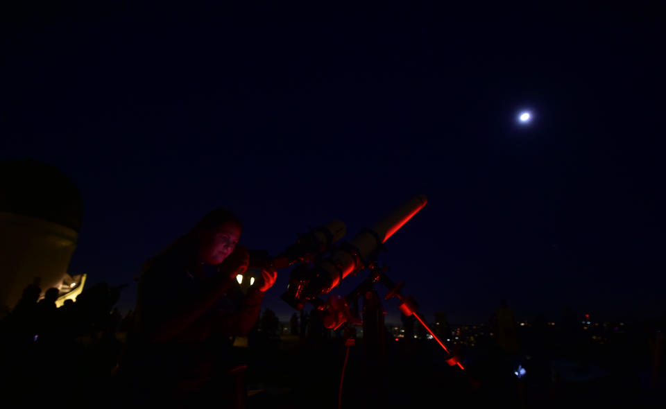 <p>Telescopes are used for a closer view as people attend the lunar eclipse celebration at Griffith Observatory in Los Angeles, Calif., in the early hours of Jan. 31, 2018, to witness the Super Blue Blood Moon, an event not seen since 1866 when three fairly common lunar happenings occur at the same time. (Photo: Frederic J. Brown/AFP/Getty Images) </p>