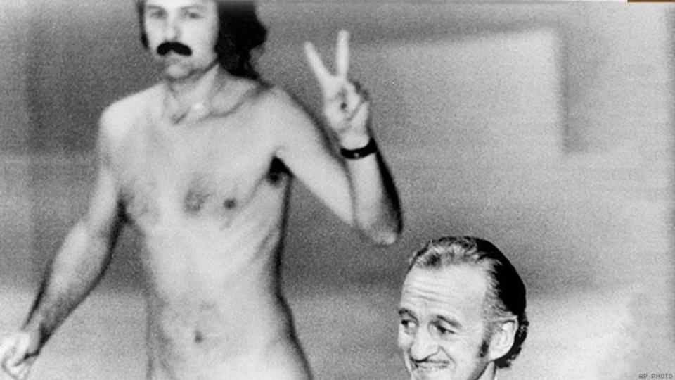 Robert Opel flashing a peace sign as he runs naked across the stage of the 46th academy awards