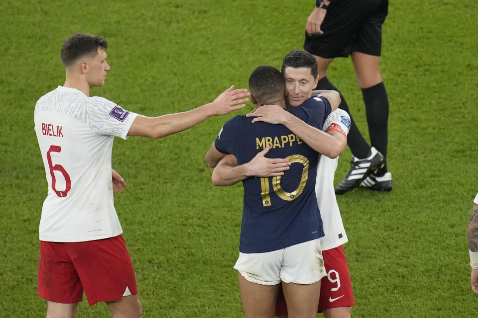 France's Kylian Mbappe is congratulated by Poland's Robert Lewandowski and Poland's Krystian Bielik at the end of the World Cup round of 16 soccer match between France and Poland, at the Al Thumama Stadium in Doha, Qatar, Sunday, Dec. 4, 2022. (AP Photo/Christophe Ena)