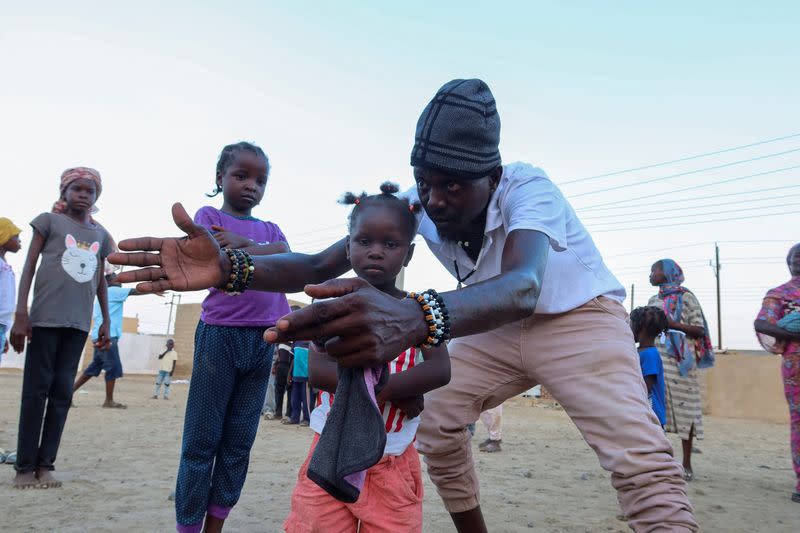 FILE PHOTO: Ganja Famer, a member of the Nuba Mountain Sound band, trains children to dance, in Port Sudan, in Sudan