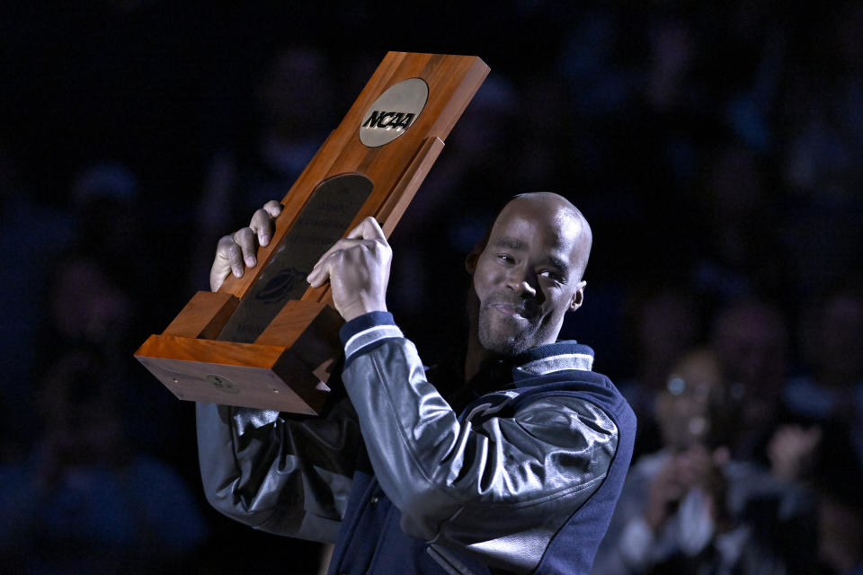Former UConn player and NBA player Emeka Okafor holds up his team's NCAA 2004 championship trophy during a halftime ceremony honoring the team during an NCAA college basketball game between UConn and Xavier, Sunday, Jan. 28, 2024, in Hartford, Conn. (AP Photo/Jessica Hill)