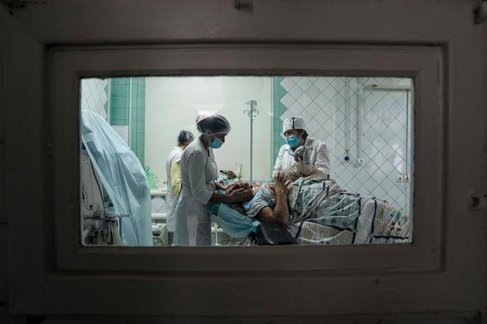 Medical workers show a newborn baby to a woman who gave birth in a maternity hospital converted into a medical ward in Mariupol, Ukraine on March 1, 2022