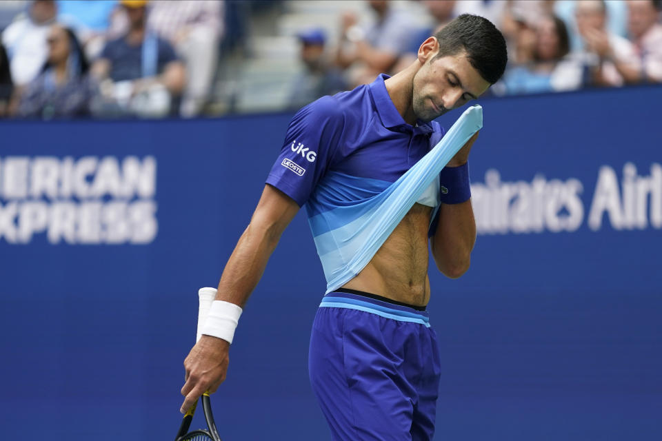 Novak Djokovic, of Serbia, wipes sweat from his face between serves from Daniil Medvedev, of Russia, during the men's singles final of the US Open tennis championships, Sunday, Sept. 12, 2021, in New York. (AP Photo/John Minchillo)