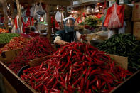 A chili pepper vendor wears a face mask and shield as a precaution against the new coronavirus at a traditional market in Jakarta, Indonesia, Tuesday, June 2, 2020. (AP Photo/Tatan Syuflana)