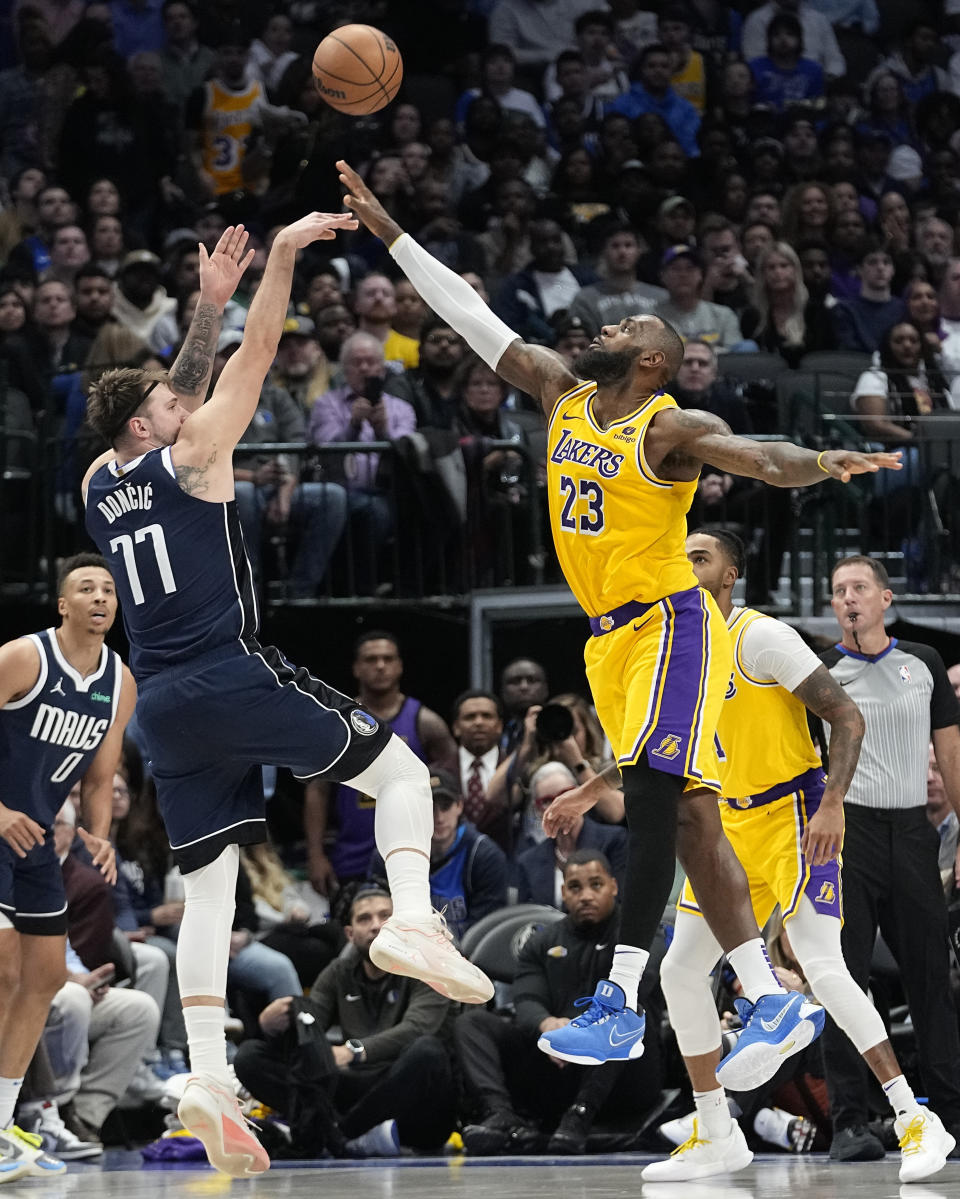 Dallas Mavericks guard Luka Doncic (77) shoots against Los Angeles Lakers forward LeBron James during the second half of an NBA basketball game in Dallas, Tuesday, Dec. 12, 2023. (AP Photo/LM Otero)