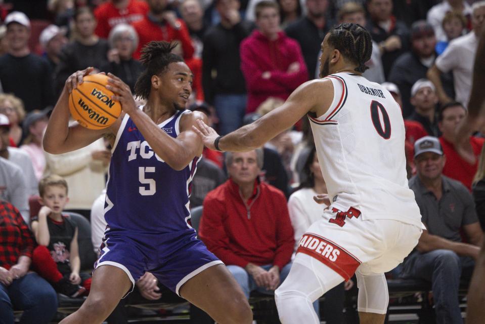TCU's Chuck O'Bannon Jr. (5) is guarded by Texas Tech's Kevin Obanor (0) during the second half of an NCAA college basketball game, Saturday, Feb. 25, 2023, in Lubbock, Texas. (AP Photo/Chase Seabolt)