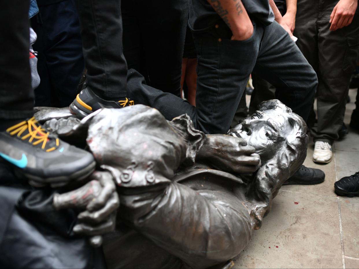 The Edward Colston statue at the feet of protesters after it was pulled down during a Black Lives Matter rally (Ben Birchall/PA)