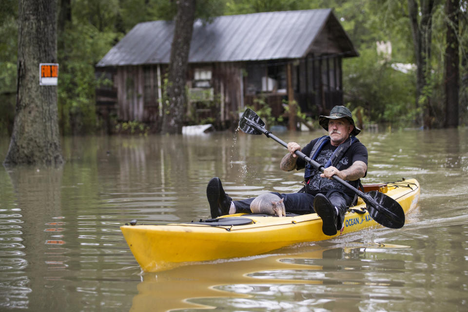 Donnie McCulley paddles out from a flooded neighborhood caused by heavy rain spawned by Tropical Depression Imelda with an armadillo as a passenger on Thursday, Sept. 19, 2019, in Patton Village, Texas. (Brett Coomer/Houston Chronicle via AP)