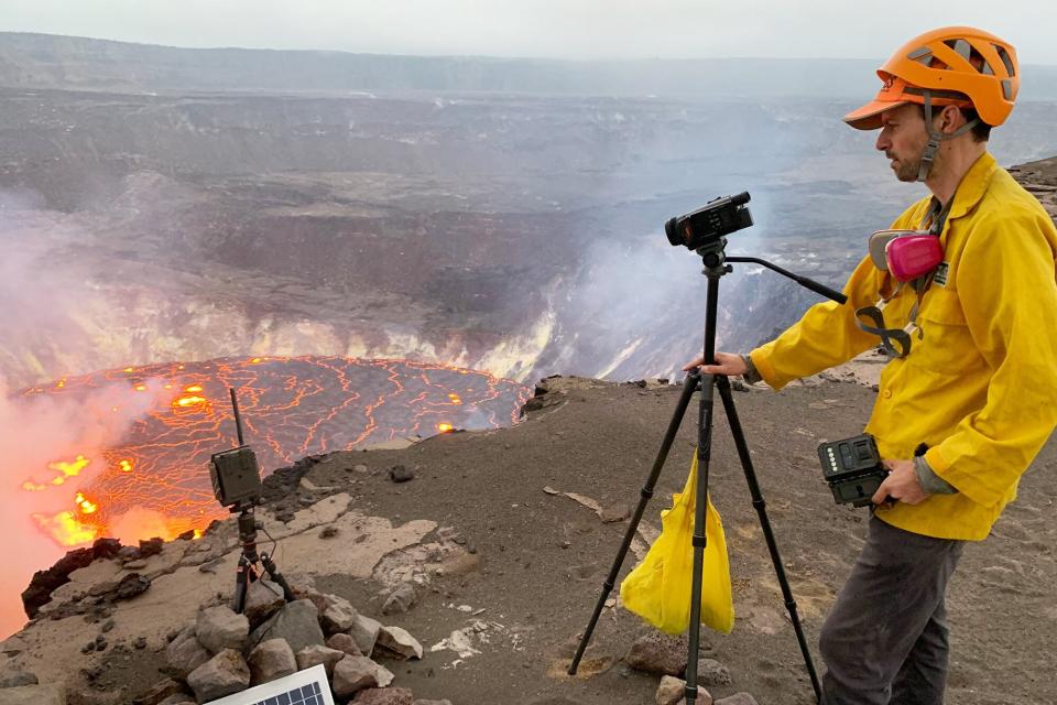 This September 29, 2021, image courtesy of the US Geological Survey (USGS) shows a USGS Hawaiian Volcano Observatory geologist taking video of the eruption Kilauea Volcano.