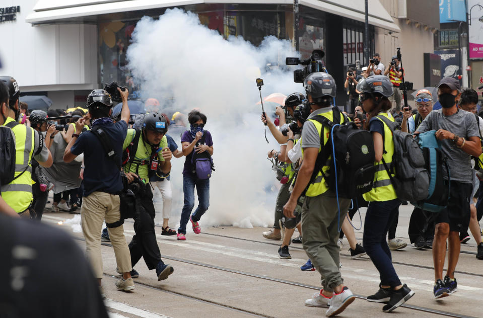 Police use tear gas in Hong Kong, Sunday, Sept. 29, 2019. Riot police fired tear gas Sunday after a large crowd of protesters at a Hong Kong shopping district ignored warnings to disperse in a second straight day of clashes, sparking fears of more violence ahead of China's National Day. (AP Photo/Gemunu Amarasinghe)