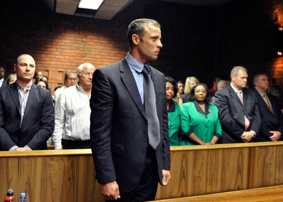 FILE – Olympian Oscar Pistorius stands following his bail hearing in Pretoria, South Africa, Tuesday, Feb. 19, 2013. Pistorius could be granted parole on Friday, Nov. 24, 2023 after nearly 10 years in prison for killing his girlfriend. The double-amputee Olympic runner was convicted of a charge comparable to third-degree murder for shooting Reeva Steenkamp in his home in 2013. He has been in prison since late 2014. (AP Photo, File)