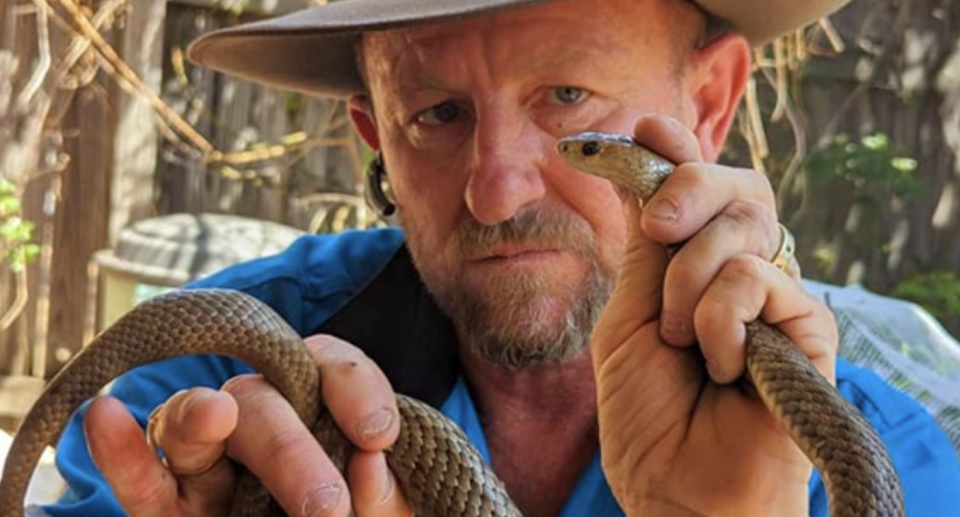 Tony Harrison is seen holding a snake. 