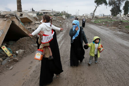 Displaced Iraqi people from the Bab al-Tob area in Mosul flee their homes after clashes to reach safe areas as Iraqi forces battle with Islamic State militants in the city of Mosul, Iraq, March 15, 2017. REUTERS/Youssef Boudlal