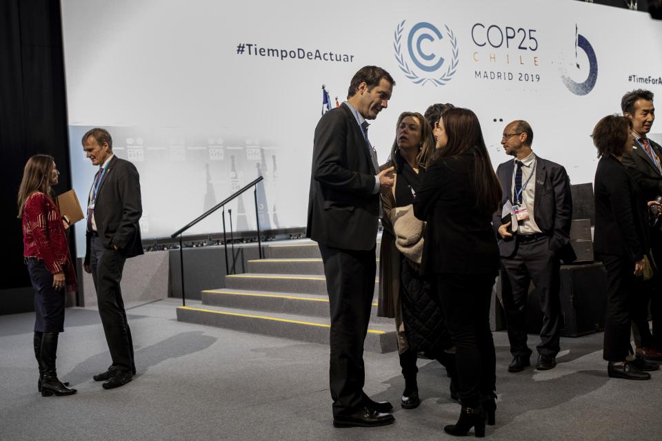 COP25 President Carolina Schmidt, left, talks with party members during the closing plenary in Madrid, Sunday Dec. 15, 2019. Negotiators from almost 200 nations planned to gather for a final time at the U.N. climate meeting in Madrid early Sunday to pass declarations calling for greater ambition in cutting planet-heating greenhouse gases and in helping poor countries suffering the effects of climate change. But one of the key issues at the talks, an agreement on international carbon markets, has eluded officials even after the Chilean chair extended Friday's talks deadline to allow more time for negotiations. (AP Photo/Bernat Armangue)