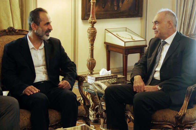 Syrian rebel leader Ahmed Moaz al-Khatib (L) with Egypt's Mohammed Kamel Amr in Cairo on November 19, 2012. Pro-regime Al-Watan newspaper describes Khatib's offer of talks as a political "manoeuvre" that comes two years too late