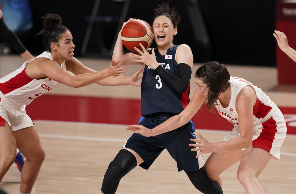 South Korea's Leeseul Kang (3), center, drives between Canada's Kia Nurse (5) and Bridget Carleton (6) during women's basketball preliminary round game at the 2020 Summer Olympics, Thursday, July 29, 2021, in Saitama, Japan. (AP Photo/Charlie Neibergall)