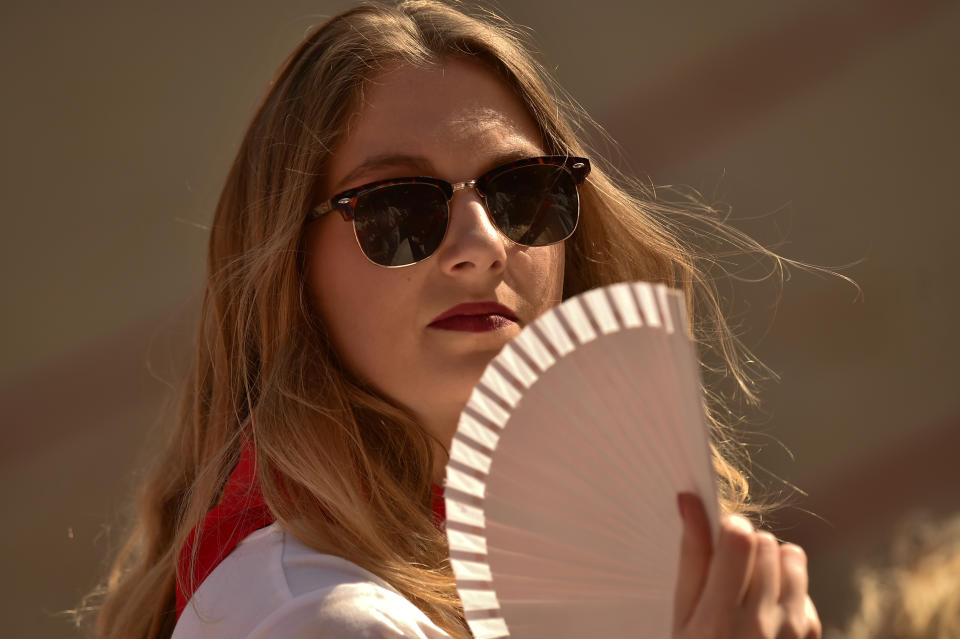 <p>A reveler waves her fans during a bullfight at the San Fermin Festival in Pamplona, northern Spain, July 11, 2018. (Photo: Alvaro Barrientos/AP) </p>