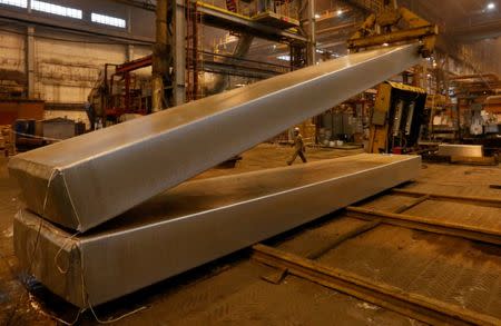 FILE PHOTO: A worker walks past a loader moving a 10.2-metre aluminium ingot weighing 28 tons (61,729 pounds) at the foundry shop of the Rusal Krasnoyarsk aluminium smelter in the Siberian city of Krasnoyarsk, Russia November 9, 2017. REUTERS/Ilya Naymushin/File Photo