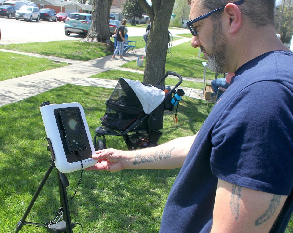 Vince Diloreto looks at the eclipse image on his smartphone Monday, April 8, 2024.