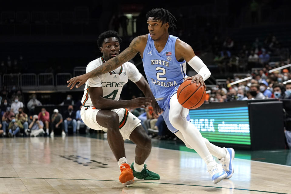 North Carolina guard Caleb Love (2) drives to the basket as Miami guard Bensley Joseph (4) defends during the first half of an NCAA college basketball game, Tuesday, Jan. 18, 2022, in Coral Gables, Fla. (AP Photo/Lynne Sladky)