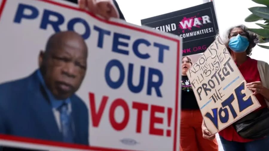 Demonstrators hold signs during a California Poor People’s Campaign protest outside the office of Democratic California Sen. Dianne Feinstein in July 2021 in Los Angeles. Protestors held similar demonstrations outside the offices of senators around the country calling for ending the filibuster, passage of the For the People Act, restoring the 1965 Voting Rights Act and increasing the federal minimum wage to $15/hour. (Photo: Mario Tama/Getty Images)