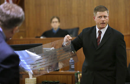 Massachusetts State Police Trooper Todd Girouard (R), holds a mylar film with the imprint of a tire track as he testifies during the murder trial of former New England Patriots football player Aaron Hernandez in Fall River, Massachusetts, March 5, 2015. REUTERS/Steven Senne/Pool